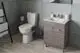Badezimmeransicht mit einem weißen WC und einem Holzwaschtisch, ausgestattet mit einem Spiegel und grundlegenden Toilettenaccessoires von Ideal Standard.
